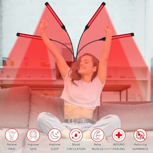 Person using red light therapy device while sitting on a couch.