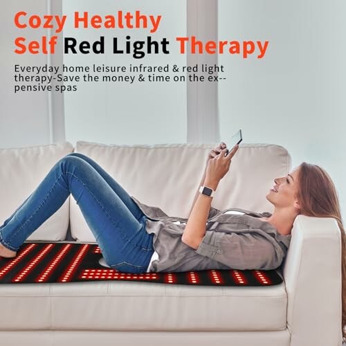 Woman using red light therapy mat on sofa