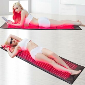 Woman using a red light therapy mat in a relaxed pose.